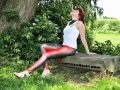 rubber redhead wearing skin tight colored latex leggings outside